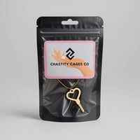 Black packaging with a gold key pendant and 'Chastity Cages Co' label on a gray background