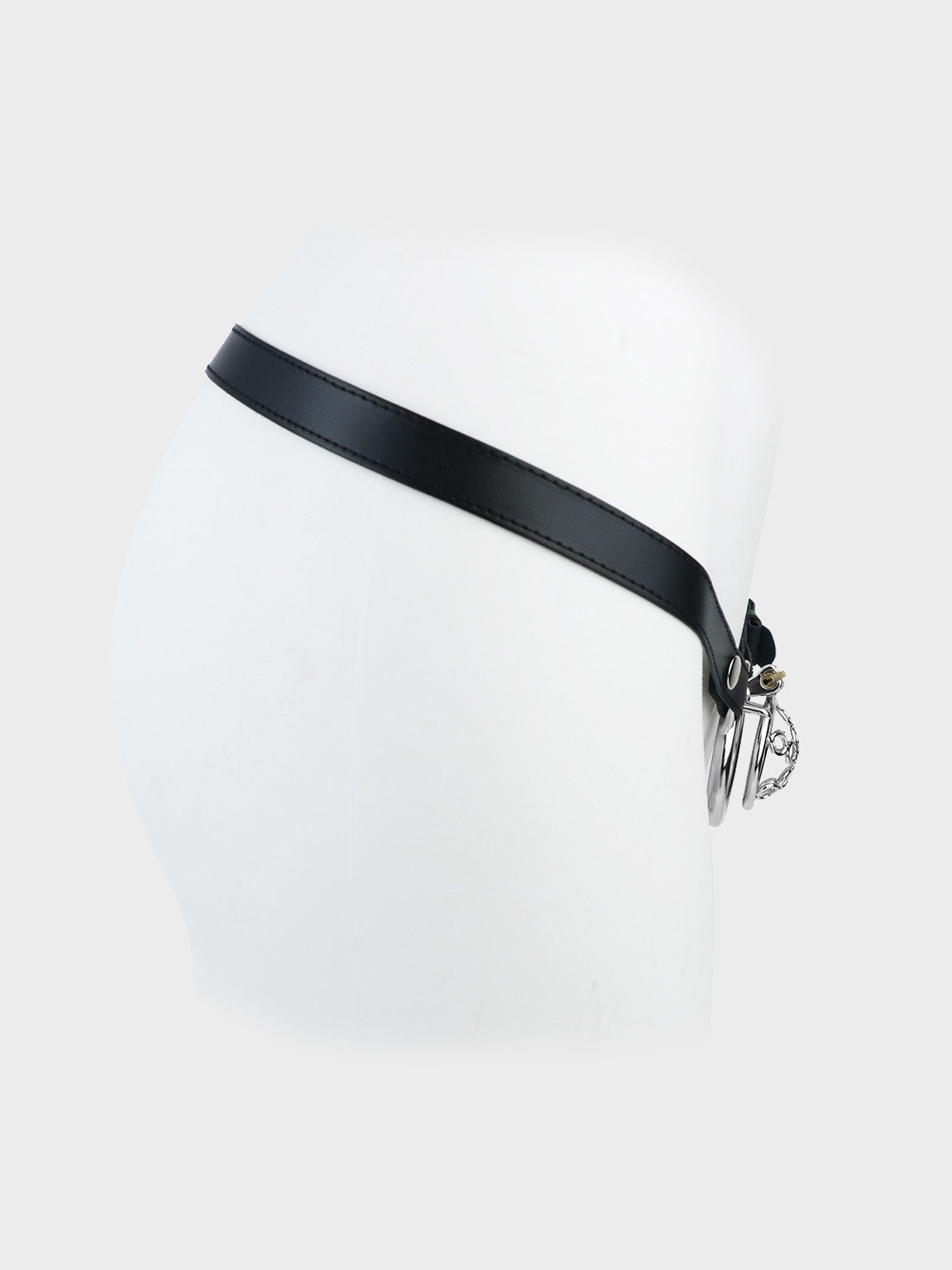 A short steel chastity cage mounted on a black leather belt.